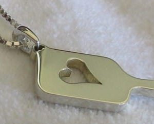 Pickleball paddle pendant with a big heart inside.